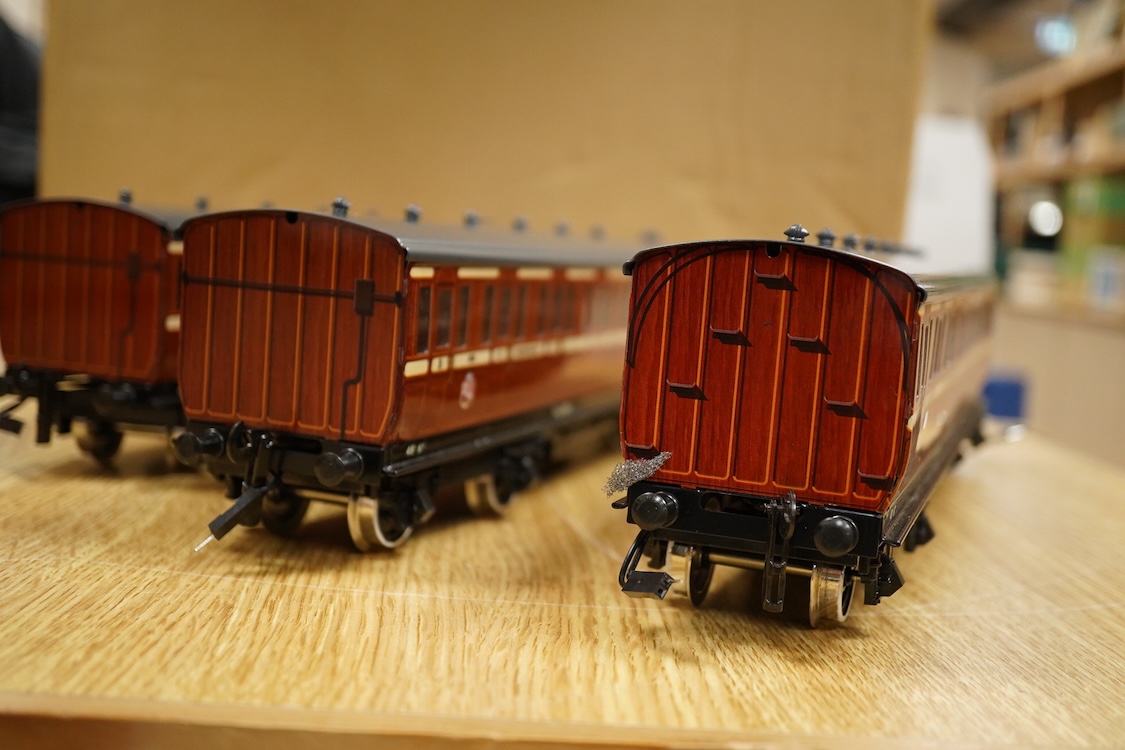 A boxed 0 gauge Darstaed tinplate Metropolitan Railway set of bogie coaches, a rake of five coaches in teak livery including; two Brake Thirds, two Full Thirds, and a Full First, fitted with internal lighting throughout